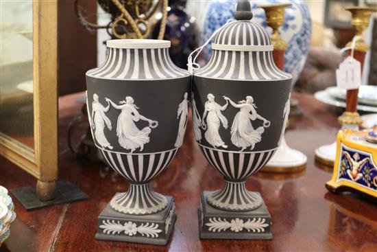 A pair of Wedgwood black jasper urn shaped vases and a cover, c.1913, height 10.5in.